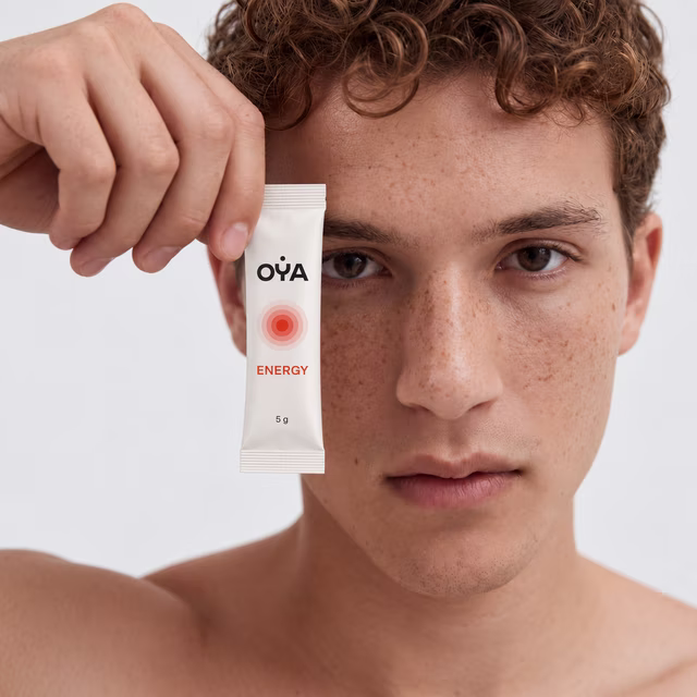 Un homme tient un stick OYA ENERGY près de son visage